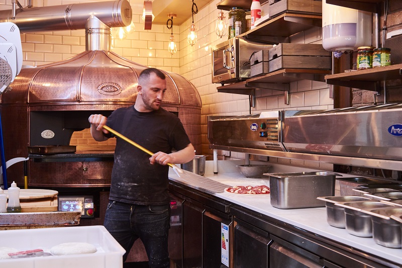 Carlo Giannini working at a pizza oven