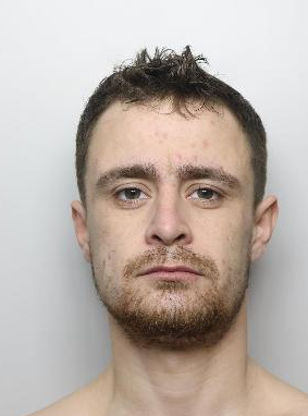 Custody picture of Connor Glen. He is a white man in his 20s with short black hair and facial hair