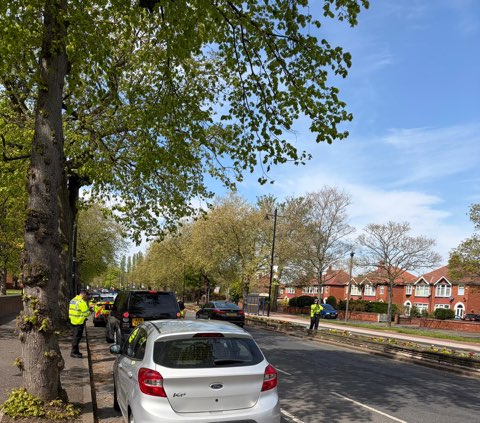A car with police officers in the distance 