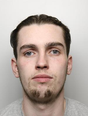 Custody image of Paddy Rooney. Rooney is a white man with short black hair that is swept back. He is in his 20s and has facial hair