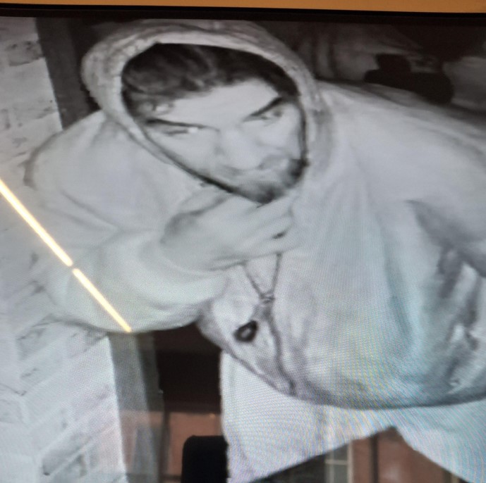 A man with dark hair wearing a hoodie