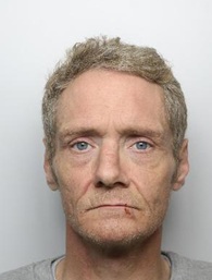 Liam Stapleton is a white man with short brown/grey hair. He is standing in front of a white background for a custody picture