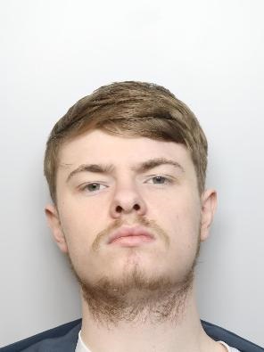 A man with a scraggy beard looks directly at the camera
