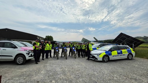 A group of officers standing together with police cars