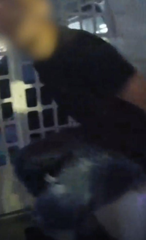 A still from an officer's body-worn video camera shows a man arrested in the back of a police van