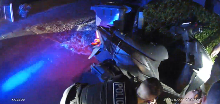 Police officers inspect a bike which has crashed into a hedge following a pursuit