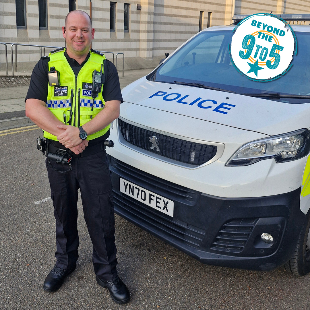 A man in police uniform stands next to a car