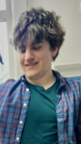 A picture of Oscar. He is a white boy with brown hair and wearing a chequered shirt