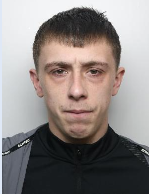 A mugshot of a white man with dark hair