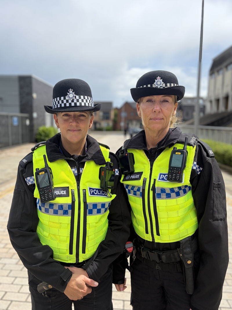 PC Vicky Green and PC Vicki Lister both dressed in high visibility police uniform. They pose for a picture on a street