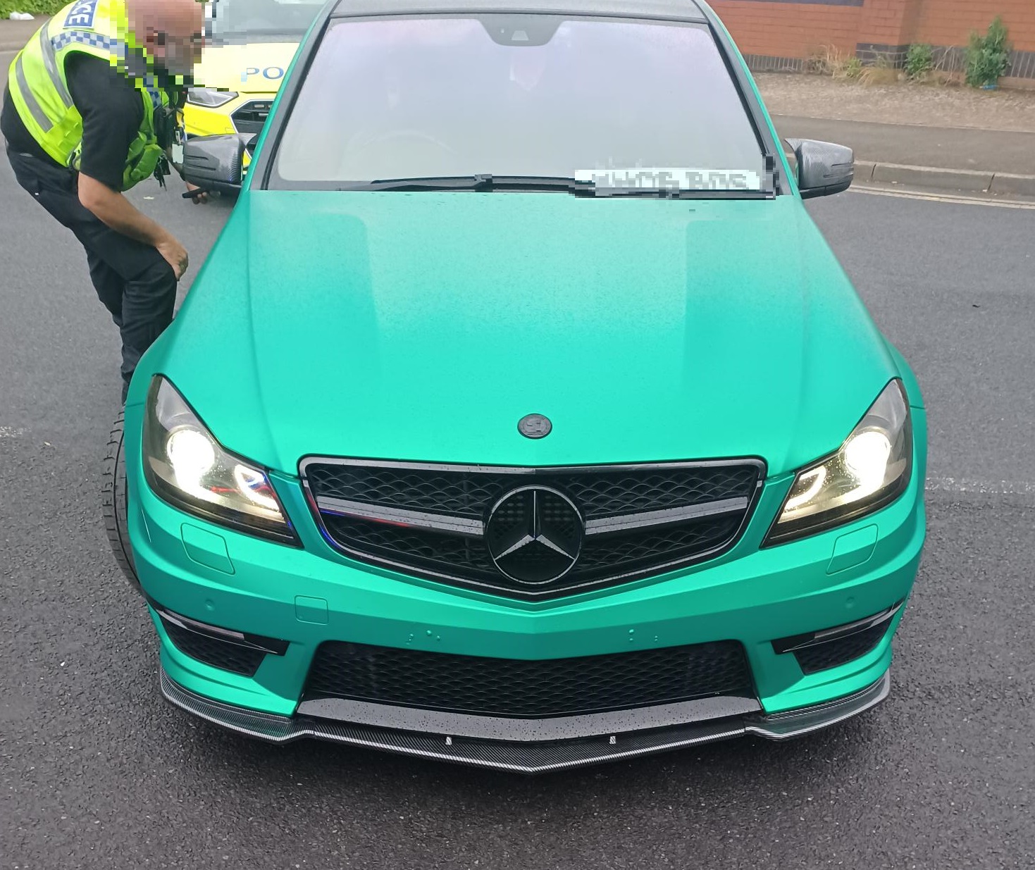 A green car that has been seized by officers 