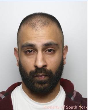 A man with a black beard and moustache with short black hair.