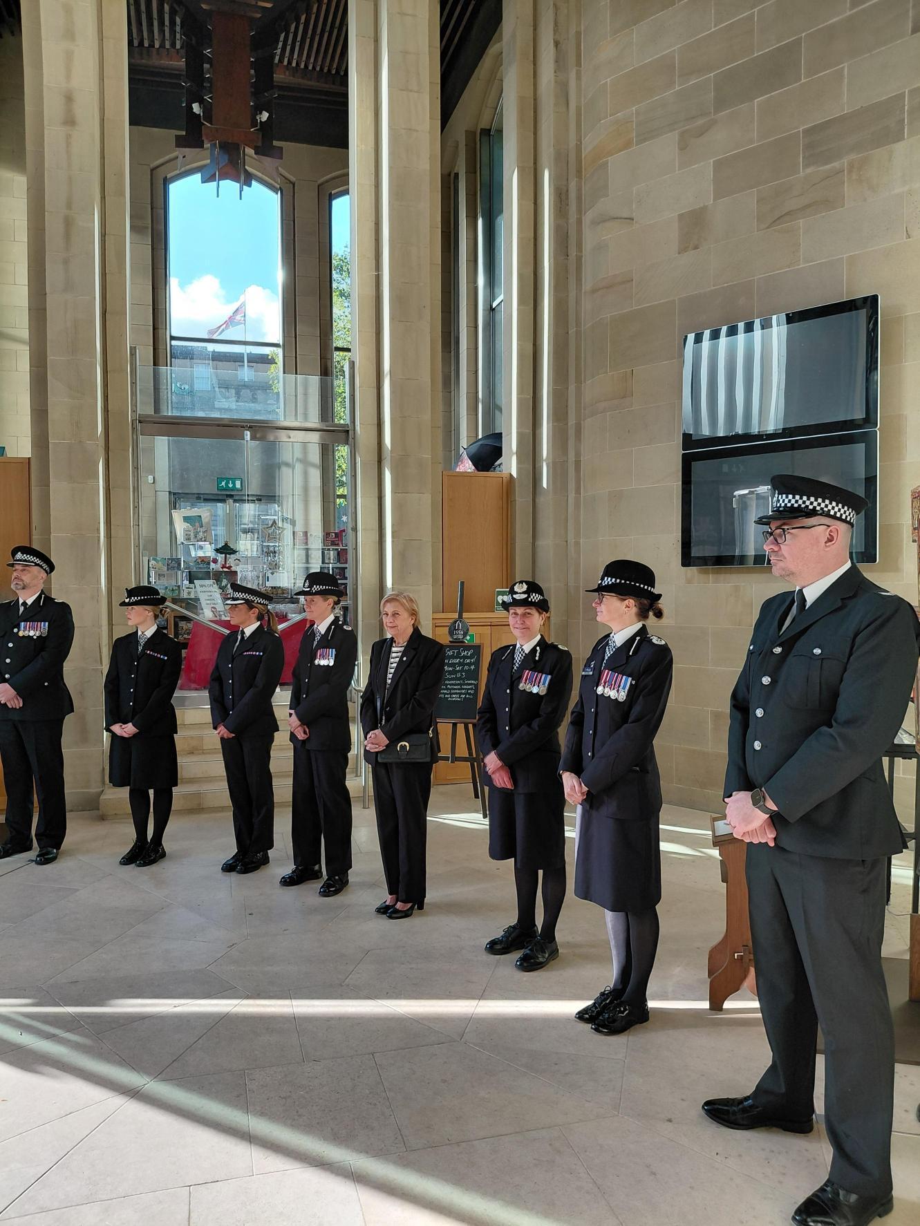 A line of police officers stand together in a cathedral