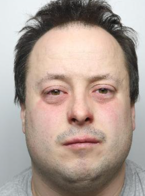 A mugshot of a man with brown hair 
