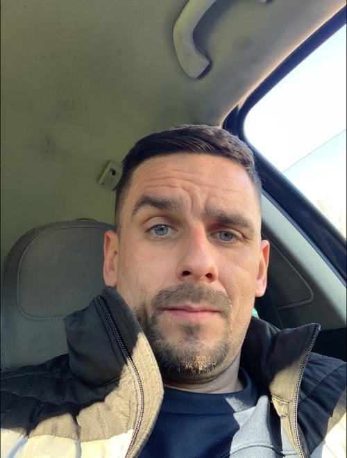 An image of a man with dark features looking at the camera 