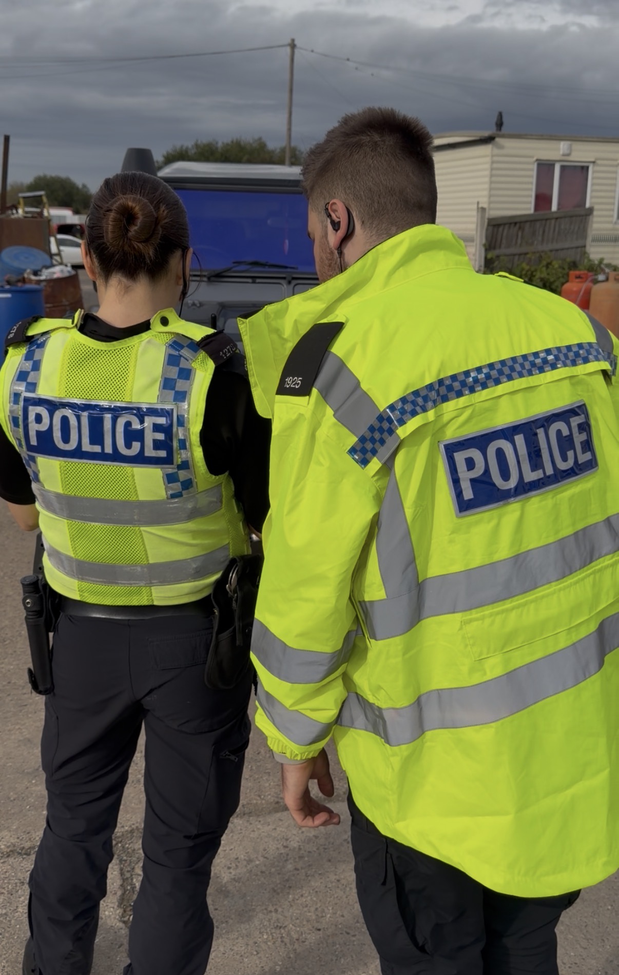 Two officers in high visibility uniform inspect a vehicle during Operation Duxford