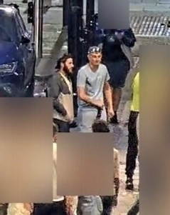 A CCTV image showing two white men walking down a street