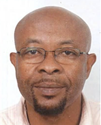 A Black man with a bald head wearing glasses. He has a short beard and moustache